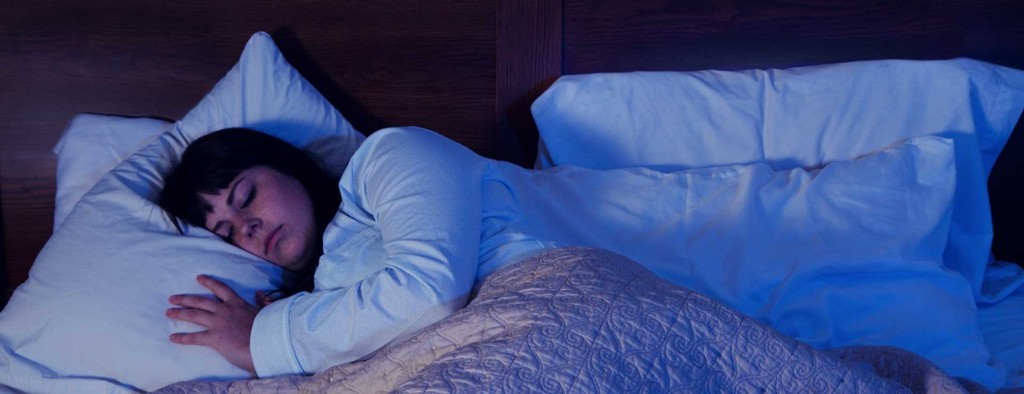 A woman peacefully sleeping in bed at night
